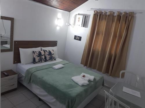 a small bedroom with two beds and a window at Vale do Pontal Angra in Angra dos Reis