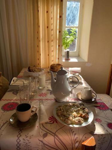 a table with a tea kettle and a plate of food at Lori's traditional house in Gjirokastër