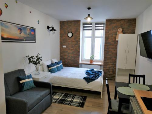 ein Schlafzimmer mit einem Bett, einem Sofa und einem Tisch in der Unterkunft theApartments Radwańska in Łódź