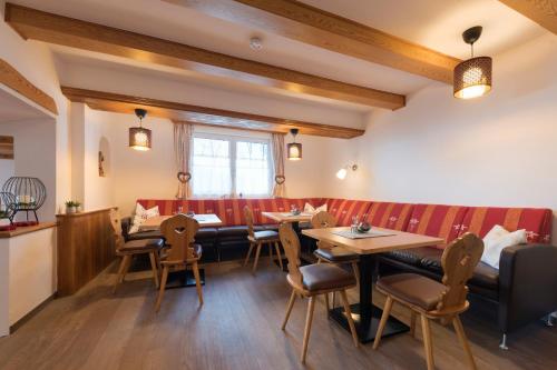 un restaurant avec des tables, des chaises et un banc dans l'établissement Chalet Rosanna, à Sankt Anton am Arlberg