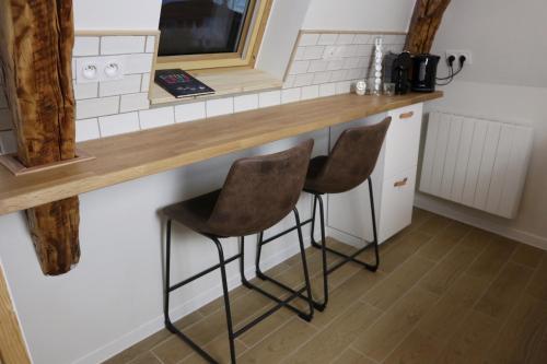 a kitchen with two stools at a counter at Villa Noellet - Clermont Ferrand in Aubière