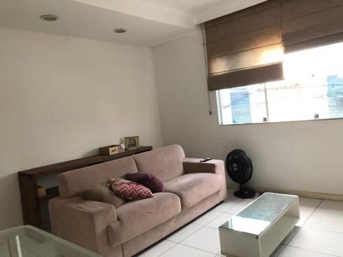 a living room with a couch and a window at Casa de Fábio in Porto Seguro