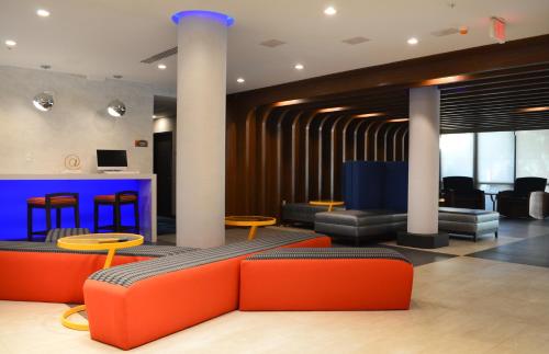 a lobby with orange and black furniture and tables at Best Western Plus Ft Lauderdale Hollywood Airport Hotel in Hollywood