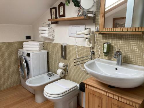 een badkamer met een toilet, een wastafel en een wasmachine bij Oasis Lagoon Estate in Venetië-Lido