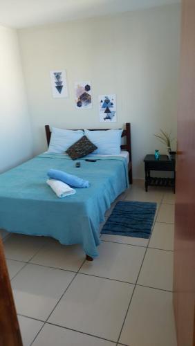 a bedroom with a bed with blue sheets and pillows at Barato e confortável AP 104 in Novo Horizonte