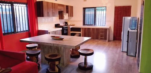 a kitchen with a wooden table and stools at Sweet Retreat in Lusaka