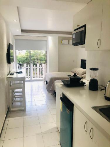 a kitchen and living room with a bed and a table at Hotel acapulco y suites mediterrane in Acapulco