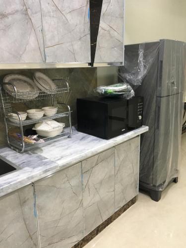 a kitchen with a microwave on a counter with at Aloche Apartments in Murree
