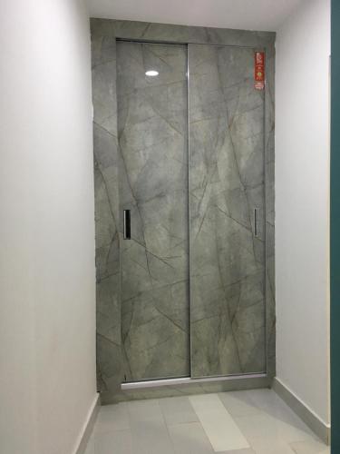 a shower with a glass door in a room at Aloche Apartments in Murree