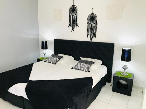 1 dormitorio con 1 cama en blanco y negro con cráneos en la pared en TIBILIK en Saint-François