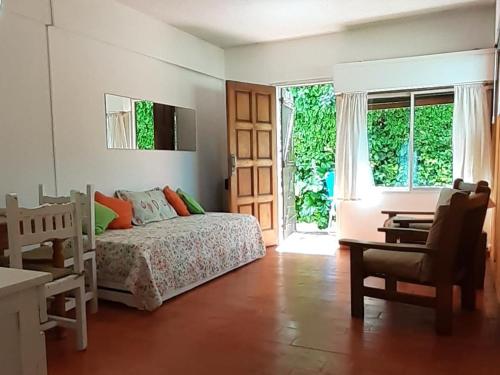 1 dormitorio con cama, escritorio y ventana en a 100mts de la PLAYA "Mar y Vida" en Pinamar