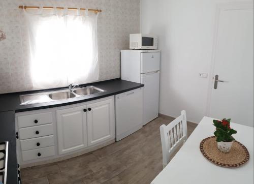 a kitchen with a sink and a kitchen table with a counter at CA NA CATALINA DEN ANDREU in Sant Francesc Xavier