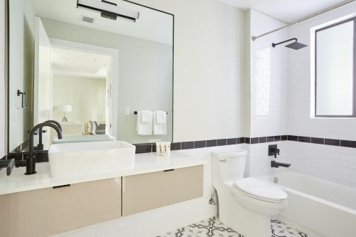 a white bathroom with a toilet and a sink at Sonder The Palace in Miami