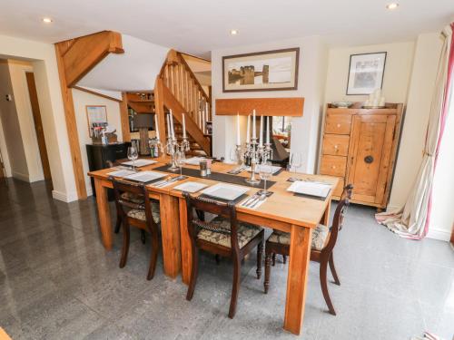 a dining room with a wooden table and chairs at Pandy Isaf in Dolgellau