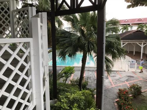uma cerca branca com uma palmeira e uma piscina em TIBILIK em Saint-François