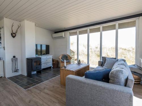 a living room with a blue couch and a tv at 4 person holiday home in Fanø in Fanø
