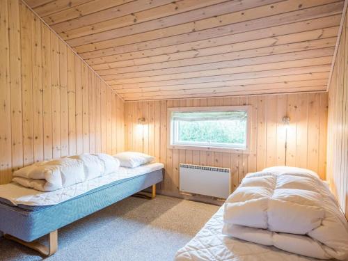 a room with a bed in a wooden room at Secluded Cozy Cottage in Skaven-By Traum in Tarm