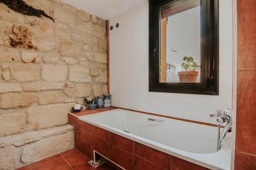 a bath tub in a bathroom with a brick wall at Villa Carpe Diem in Zarratón