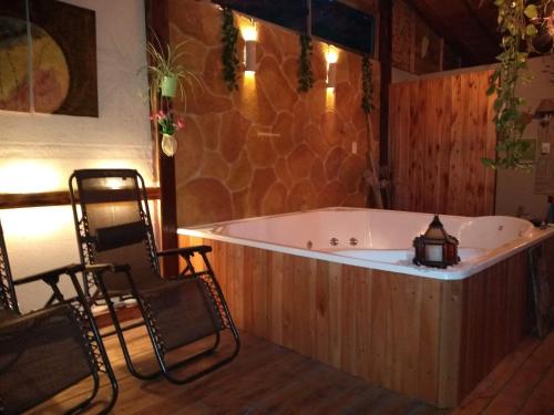 a large bath tub in a room with two chairs at Pualy Resort & Spa in Belén de Escobar