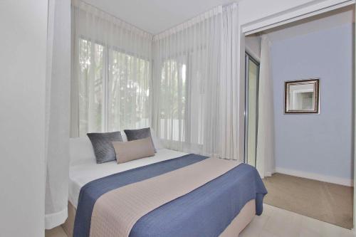Un dormitorio con una cama y una ventana grande. en PalmCove DriftAway, en Palm Cove