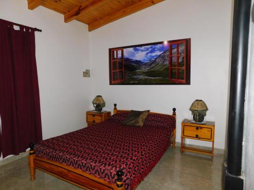 um quarto com uma cama e um quadro na parede em Cabañas Mirmar Mendoza em Mendoza