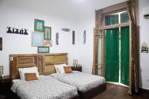 two beds in a room with green shutters at Cairo International Hostel Downtown in Cairo