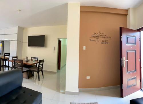 a living room with a table and a door at Garzota Suites Airport Bajos in Guayaquil
