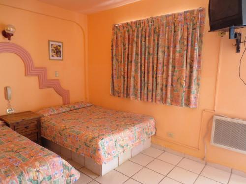 a bedroom with two beds and a window at Hotel Plaza Peñasco in Puerto Peñasco