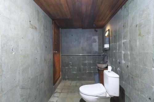 a bathroom with a white toilet in a room at Waterside inn Nusa Penida in Nusa Penida