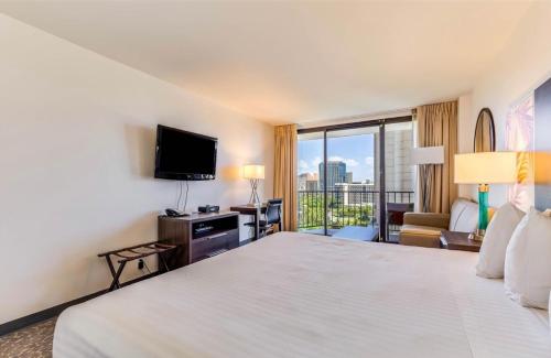 a hotel room with a large bed and a television at Aqua Palms Waikiki #304 and #1112 in Honolulu