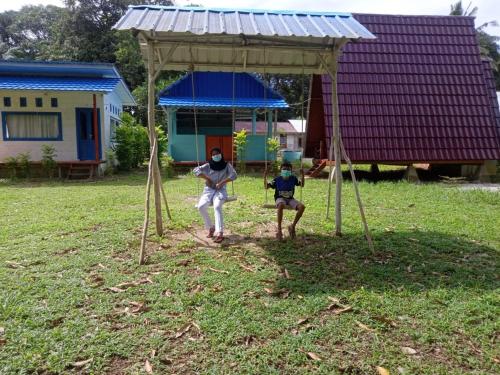 two people playing a game in a gazebo at Tanjong Tinggi Cottage in Sijuk