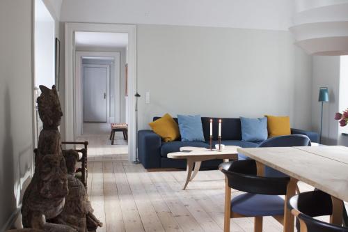 a living room with a blue couch and a table at ApartmentInCopenhagen Apartment 1185 in Copenhagen