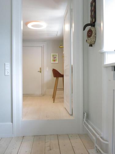 a hallway with a white door and a wooden floor at ApartmentInCopenhagen Apartment 1185 in Copenhagen