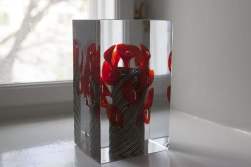 a vase with a red flower on a table at ApartmentInCopenhagen Apartment 1185 in Copenhagen