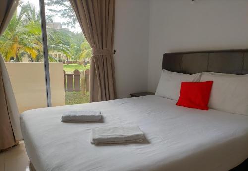 a bedroom with a bed with two towels on it at Seri Bayu Resort Hotel in Kampong Bagan Lalang
