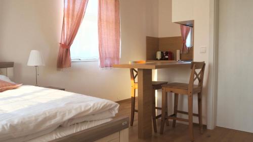 um quarto com uma cama e uma secretária com uma cadeira em Apartmány Na Potoku em Slavonice