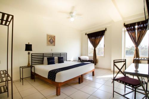 - une chambre avec un lit, une chaise et des fenêtres dans l'établissement Hotel Plaza Galindo, à San Juan de los Lagos