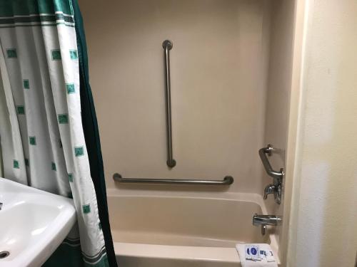 a bathroom with a bath tub and a sink at Empire Inn & Suites Absecon/Atlantic City in Absecon