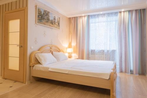 トムスクにあるApart Petrovskie on Yeniseyskaya 3のベッドルーム1室(ベッド1台、大きな窓付)