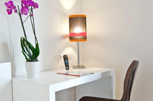 a white desk with a lamp and a vase of flowers at Hotel Caravel in Rome