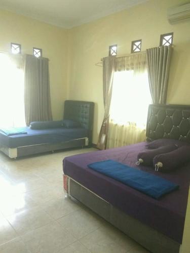 1 dormitorio con 2 camas y ventana en Rumah Puan Homestay, en Bandar Lampung