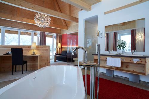 a bathroom with a bath tub in a room at Romantik Resort & SPA Der Laterndl Hof in Haldensee