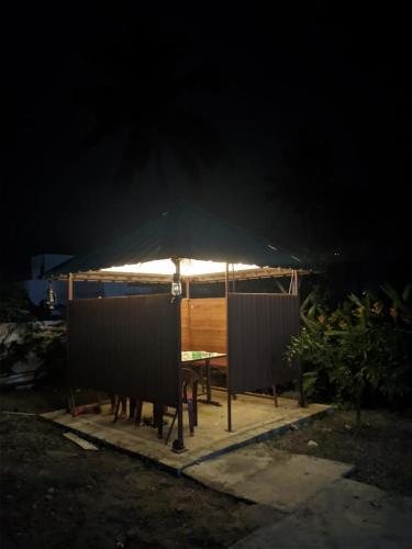 a picnic table with a black umbrella at night at Kadampil Bliss in Marayoor