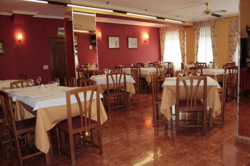 a dining room with white tables and chairs at Hotel Peñagrande in Cangas del Narcea