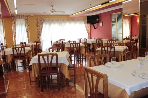 a dining room with white tables and chairs at Hotel Peñagrande in Cangas del Narcea