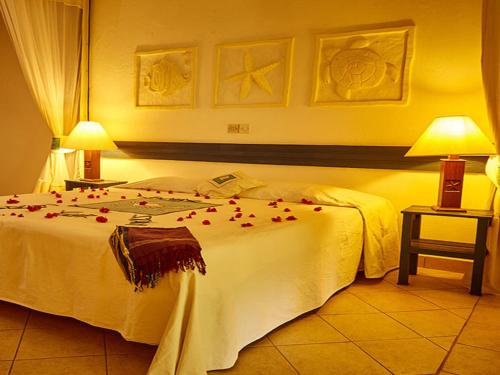 a bedroom with a bed with red roses on it at Pinewood Beach Resort and Spa in Diani Beach