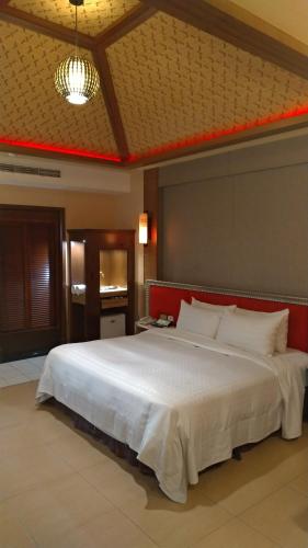 um quarto com uma grande cama branca num quarto em I Travel Motel em Kaohsiung