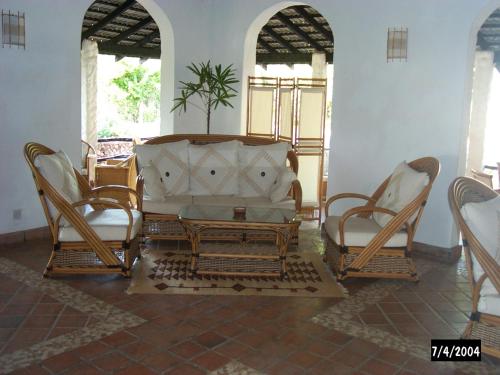 a living room with a couch and two chairs at Pinewood Beach Resort and Spa in Diani Beach