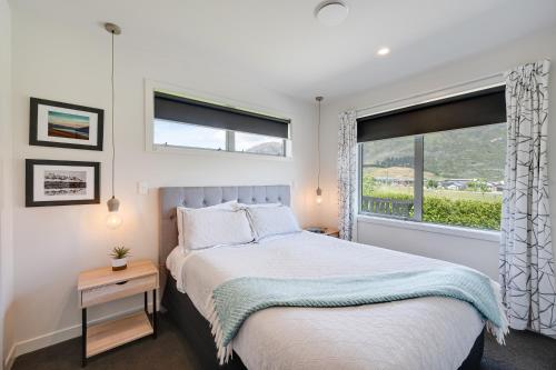 a bedroom with a large bed and a window at Little Piece of Paradise in Queenstown