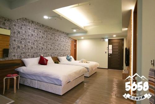 a bedroom with two beds and a wall at Hotel Blessings in Kaohsiung
